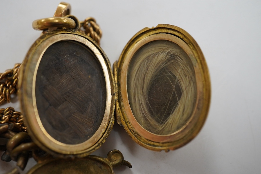 A Victorian yellow metal oval locket, with rope twist band, overall 29mm and a yellow metal fob chain. Condition - fair